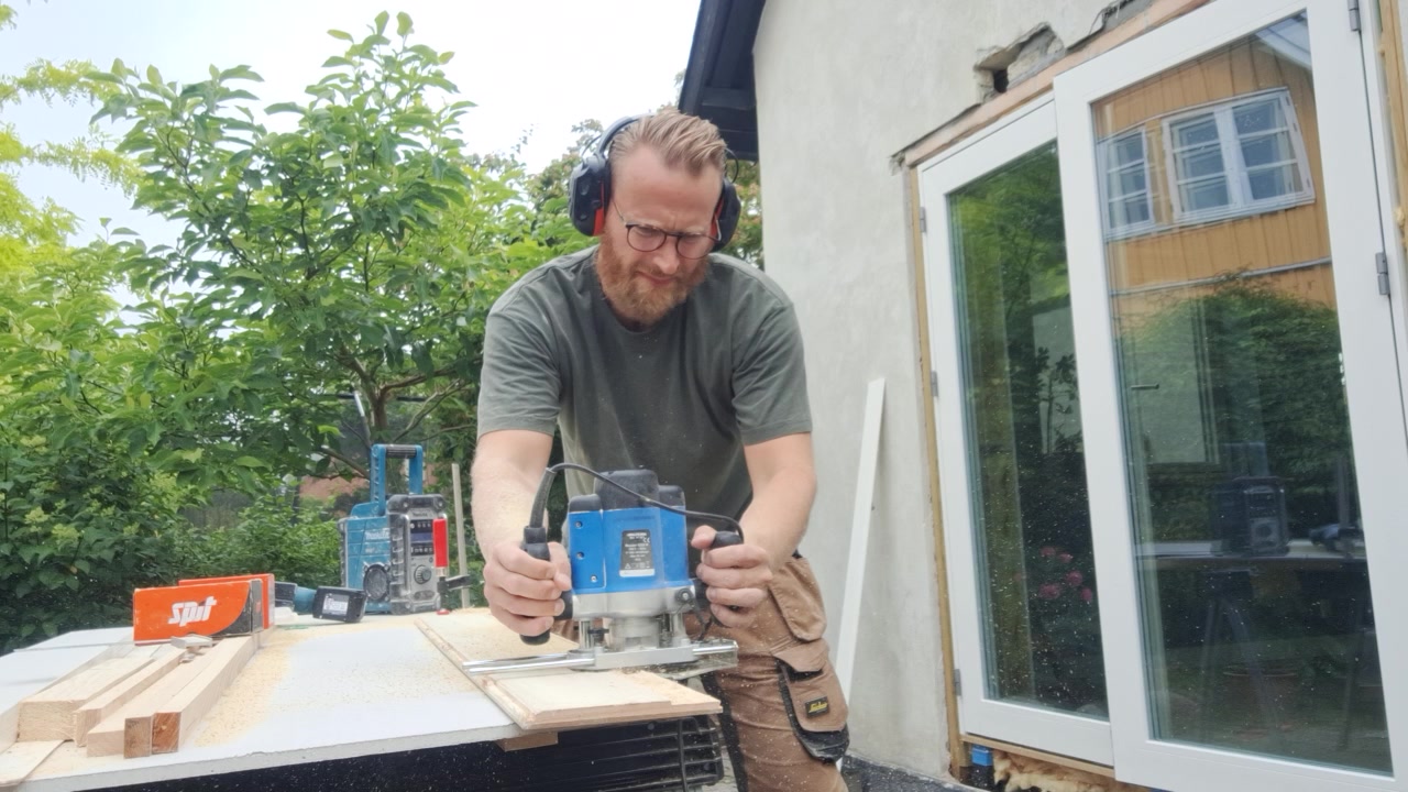 Tømrermester Thomsen arbejder med overfræser på et tømrerprojekt i Farum